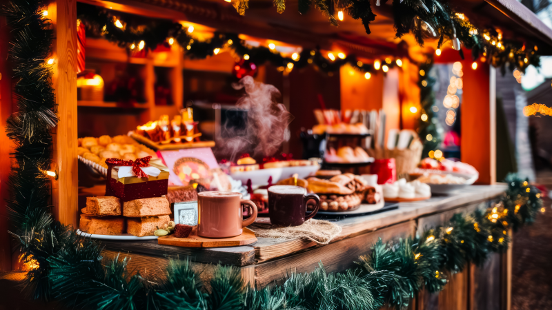Bild från en julmarknad med ett ställe där man köpa kakor och varm choklad. 