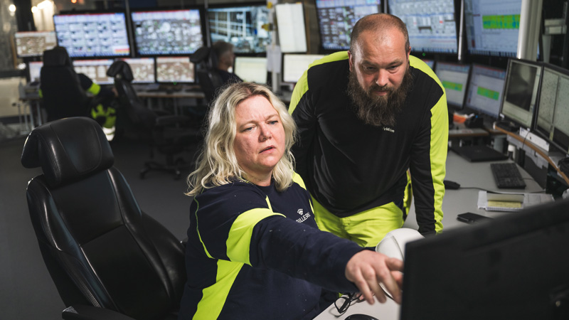 Kvinna och man vid datorskärm i industrimiljö.