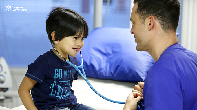 Barn lyssnar på läkarens hjärta.