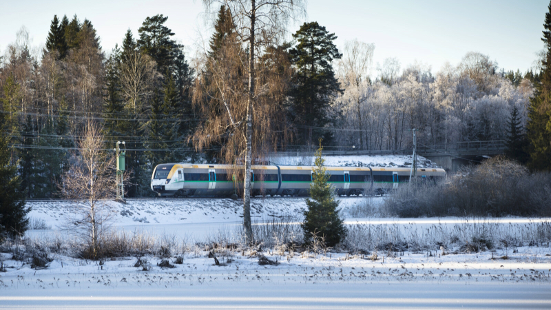 Tåg som far fram i vinterlandskap