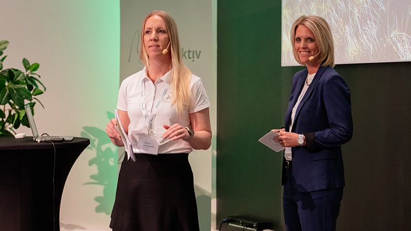 Två kvinnor pratar på en scen.