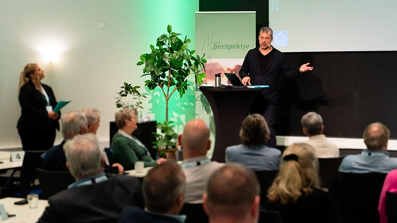 En man pratar på en scen framför en publik.