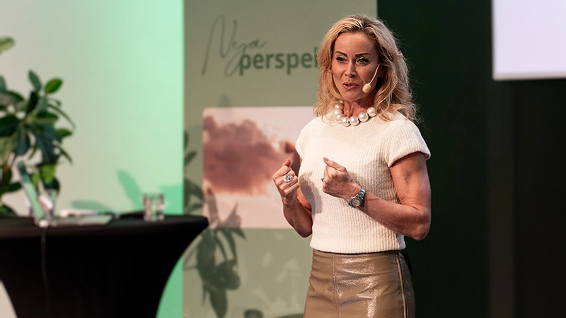 Kvinna som står på en scen och föreläser