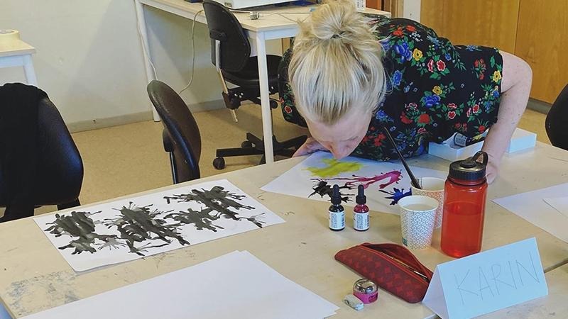 Kvinna tittar på blobbar på ett papper.