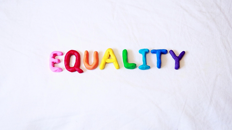 Ordet equality formade i lera i många olika färger.