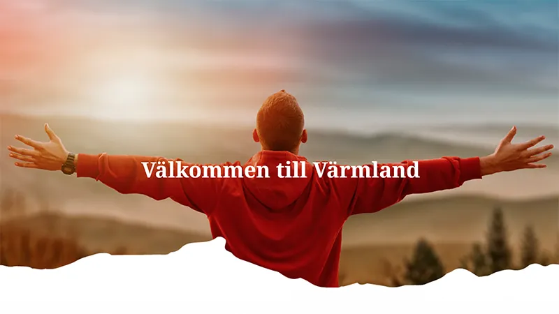 Välkommen till Värmland. Man står framför ett landskap med armarna utsträckta.