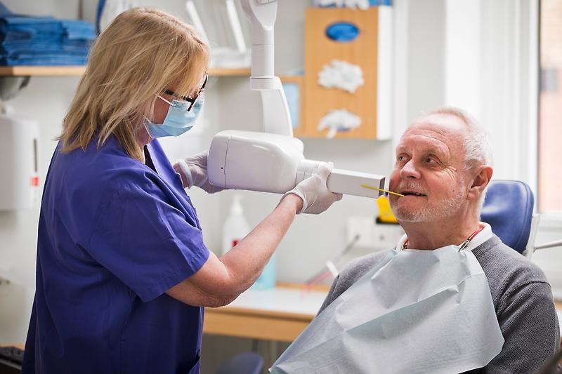 tandhygienist tar röntgenbilder på patient