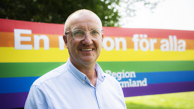 Bilden visar regiondirektör Peter Bäckstrand. Bakom honom finns en banderoll med texten "En region för alla, Region Värmland"