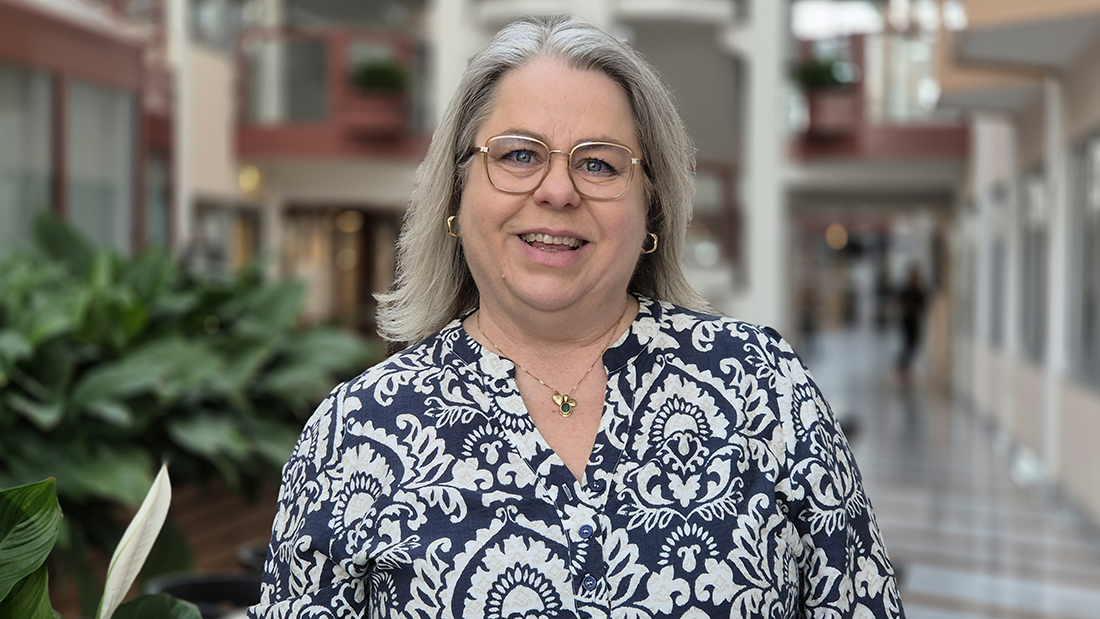 En kvinna ler och tittar in i kameran.