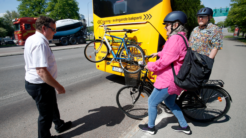 Två pensionärer som ska lasta på sina cyklar i bak på en buss