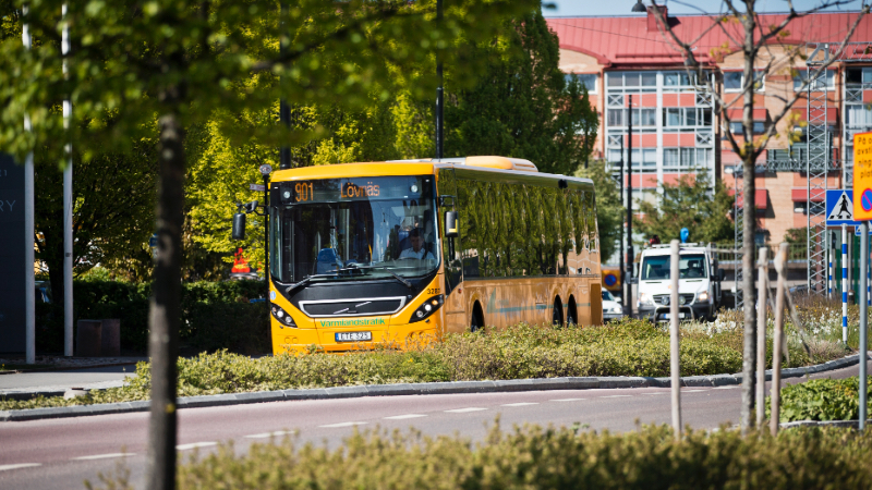 En gul regionbuss linje 901 mot Lövnäs kör i trafik i Karlstad