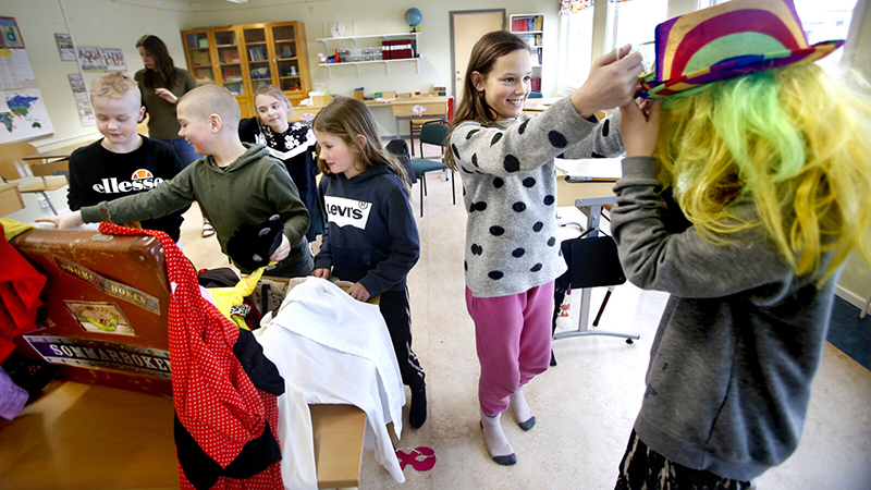 Barn som klär ut sig i ett klassrum.