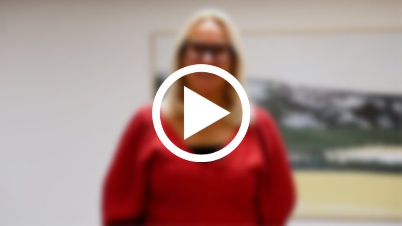 Skärmklipp från video med kvinna i oskärpa och en playsymbol som signalerar ett videoklipp.