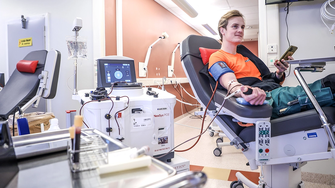 Person som ligger på en brits med armen utsträckt och lämnar plasma.