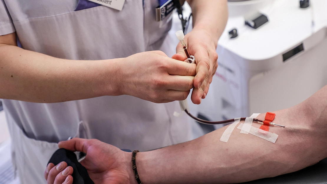 Närbild på plasmatappning - en nål i en arm.