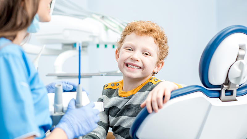 Barn sitter i tandläkarstol