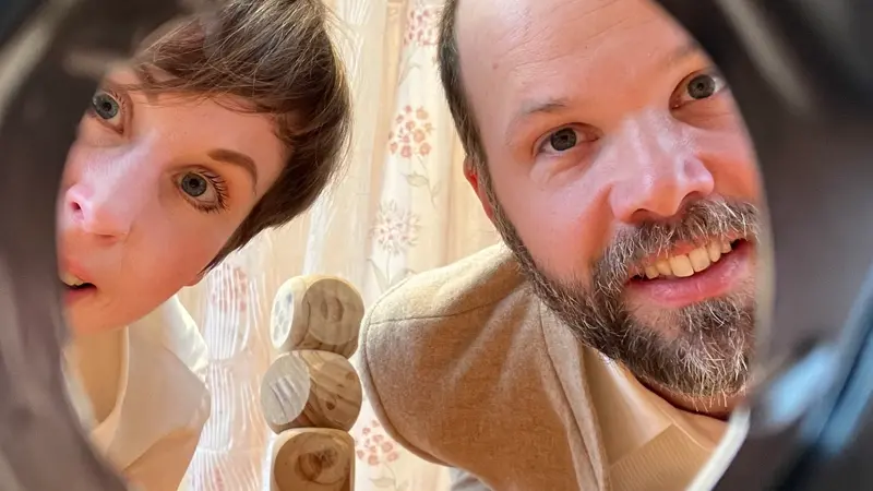 En man och en kvinna tittar ut genom ett hål.