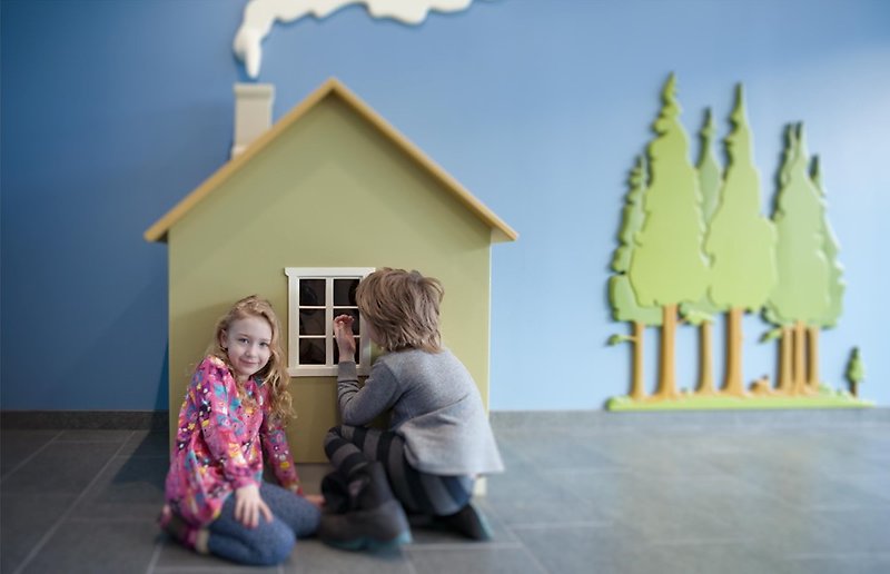 Två barn framför konstnären Henric Westlunds verk I ett hus vid skogens slut. 