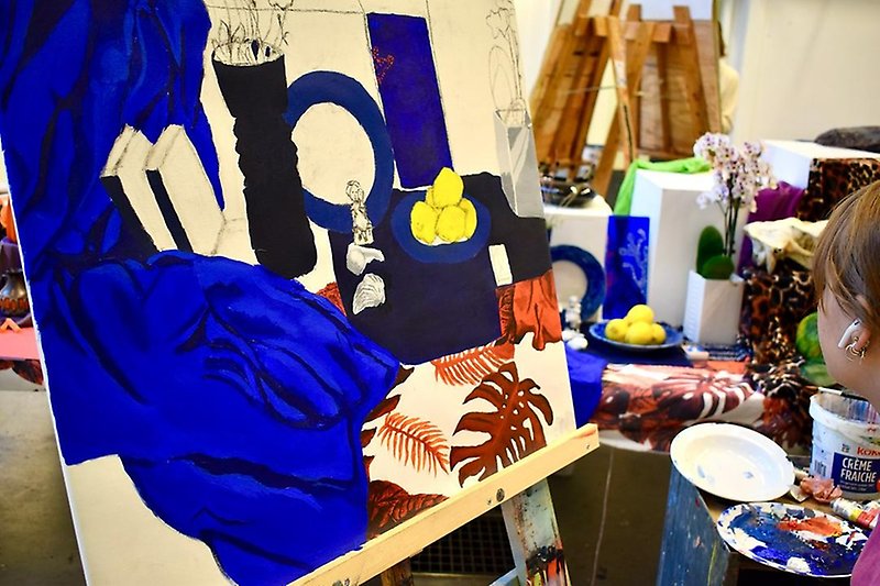 En person målar stilleben i blått och gult
