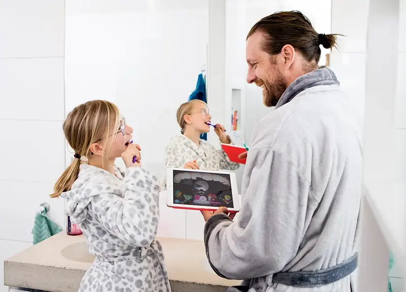 pappa och dotter borstar tänder till Rocka munnen-spelet